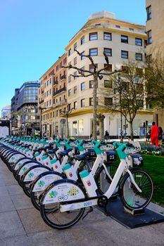 Row of rental bicycles on a city street, ready for urban commuters.