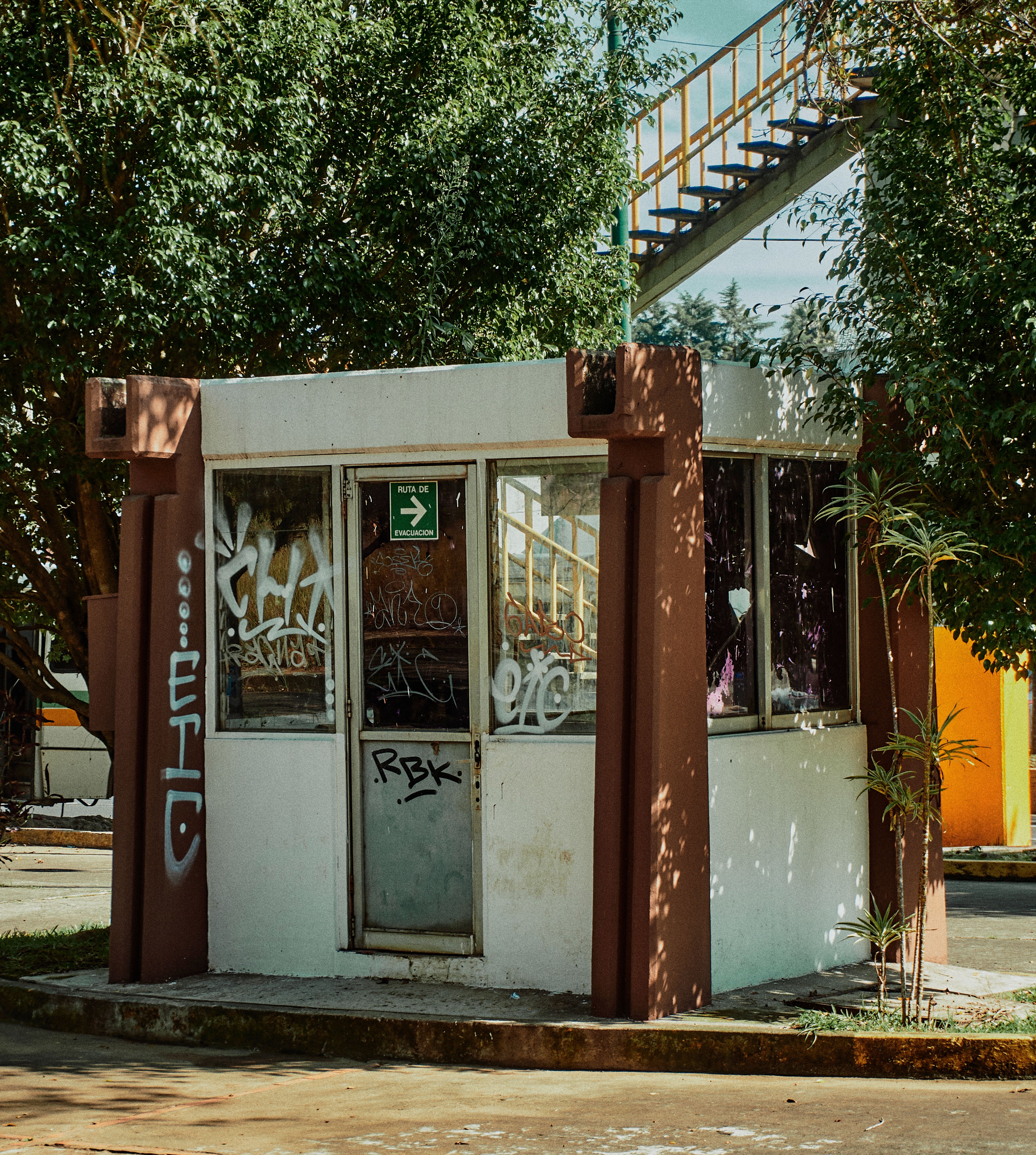 An urban scene featuring an abandoned kiosk covered with graffiti in Xalapa, Mexico.