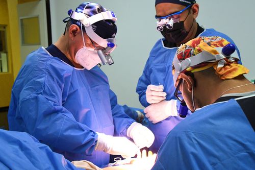 Free Team of surgeons focuses on a precise operation in a well-equipped surgical room, showcasing teamwork and expertise. Stock Photo