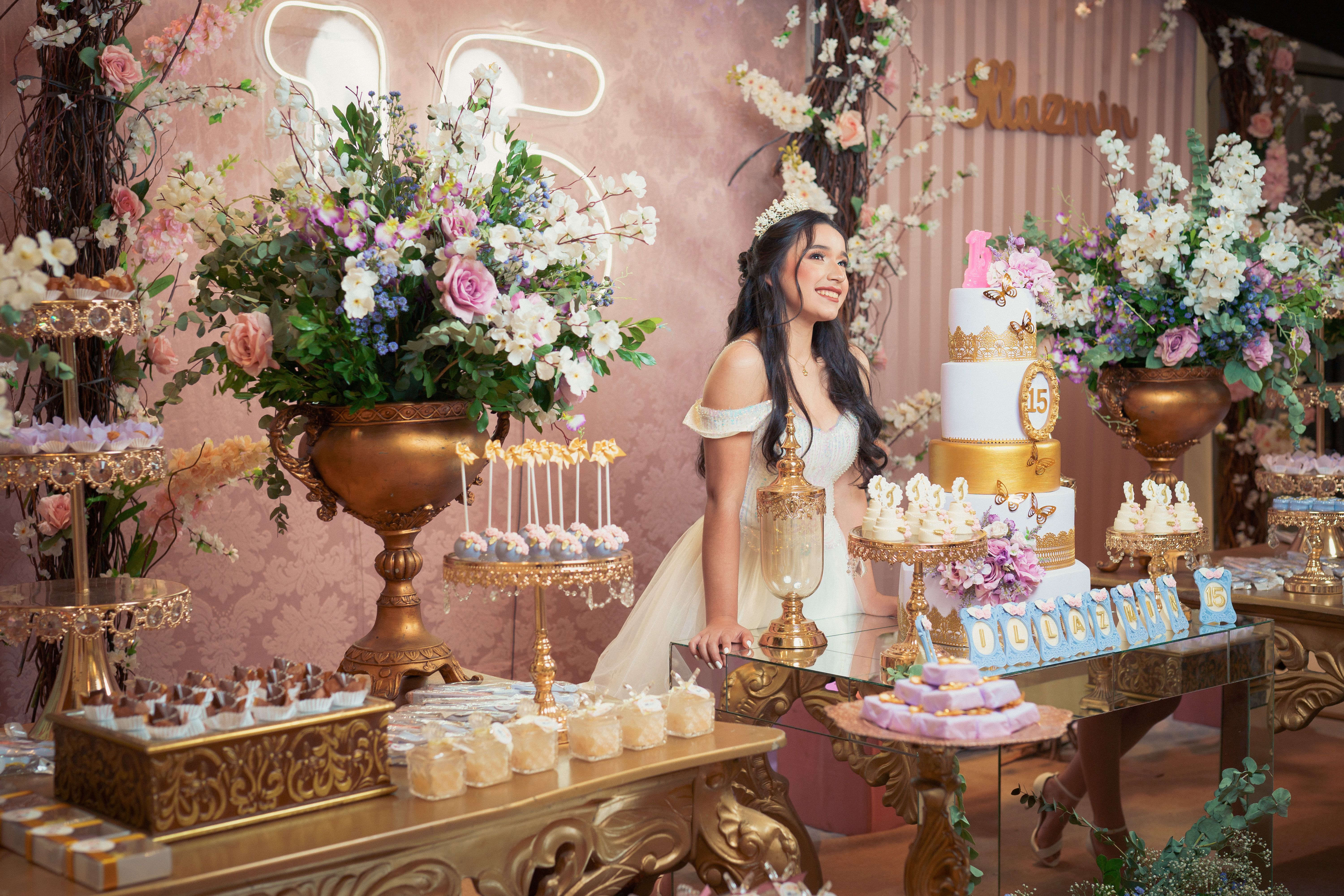 A beautiful quinceañera celebration with a teenage girl in a white dress, surrounded by elegant decorations and a tiered cake.
