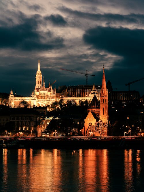 View of Illuminated Fishermans Bastion and Church under a Cloudy Sky at Dusk in Budapest, Hungary 