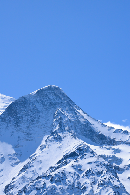 Free Stunning view of a snowcapped mountain peak against a clear blue sky. Stock Photo