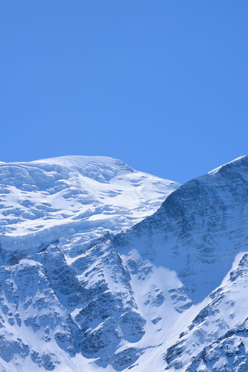 Free Majestic snow-covered mountains under a clear blue sky, showcasing winter's beauty. Stock Photo