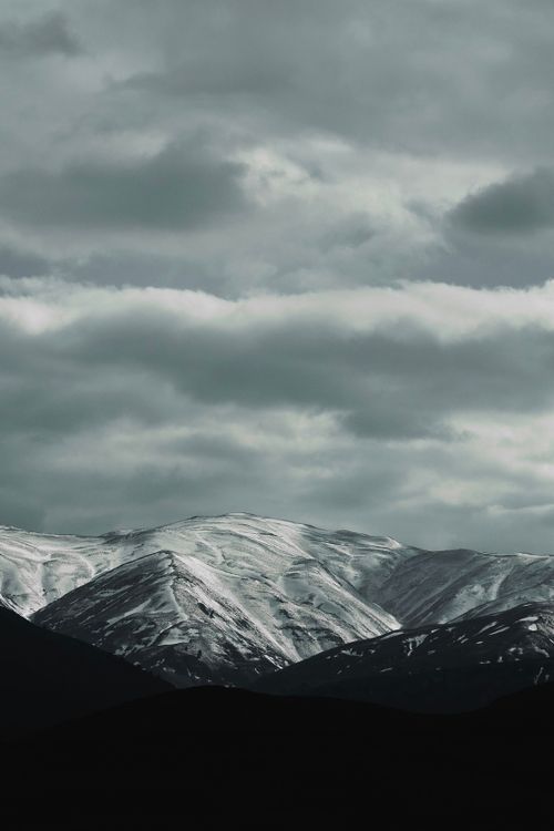 Free Majestic snow-capped mountains with dense clouds in Mashhad, Iran. Stock Photo