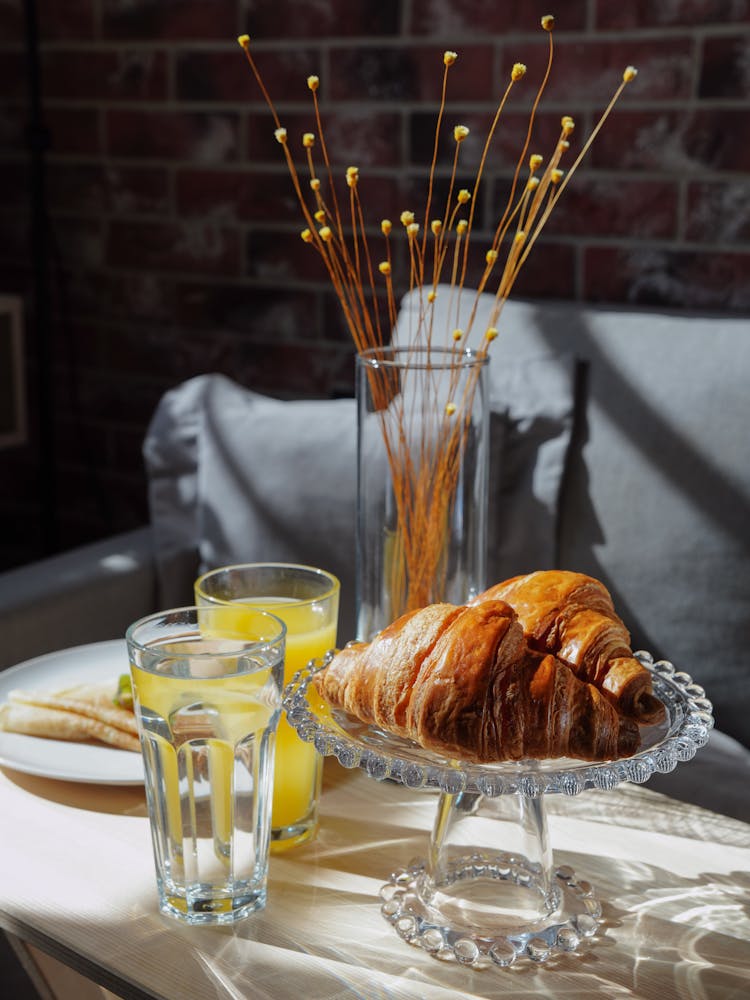 Fresh Croissants And Juice On Table