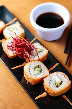 Crispy sushi rolls served with soy sauce, captured artistically indoors.