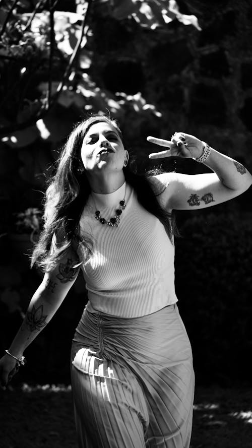 Young Woman Walking Outdoors and Showing Peace Sign 