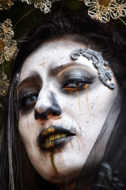Free Close-up portrait of a mysterious woman with dramatic artistic makeup, gothic elements, and haunting expression. Stock Photo
