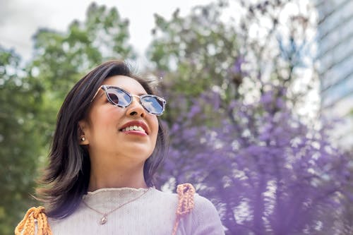 Low Angle Shot of a Young Brunette in Sunglasses in City 