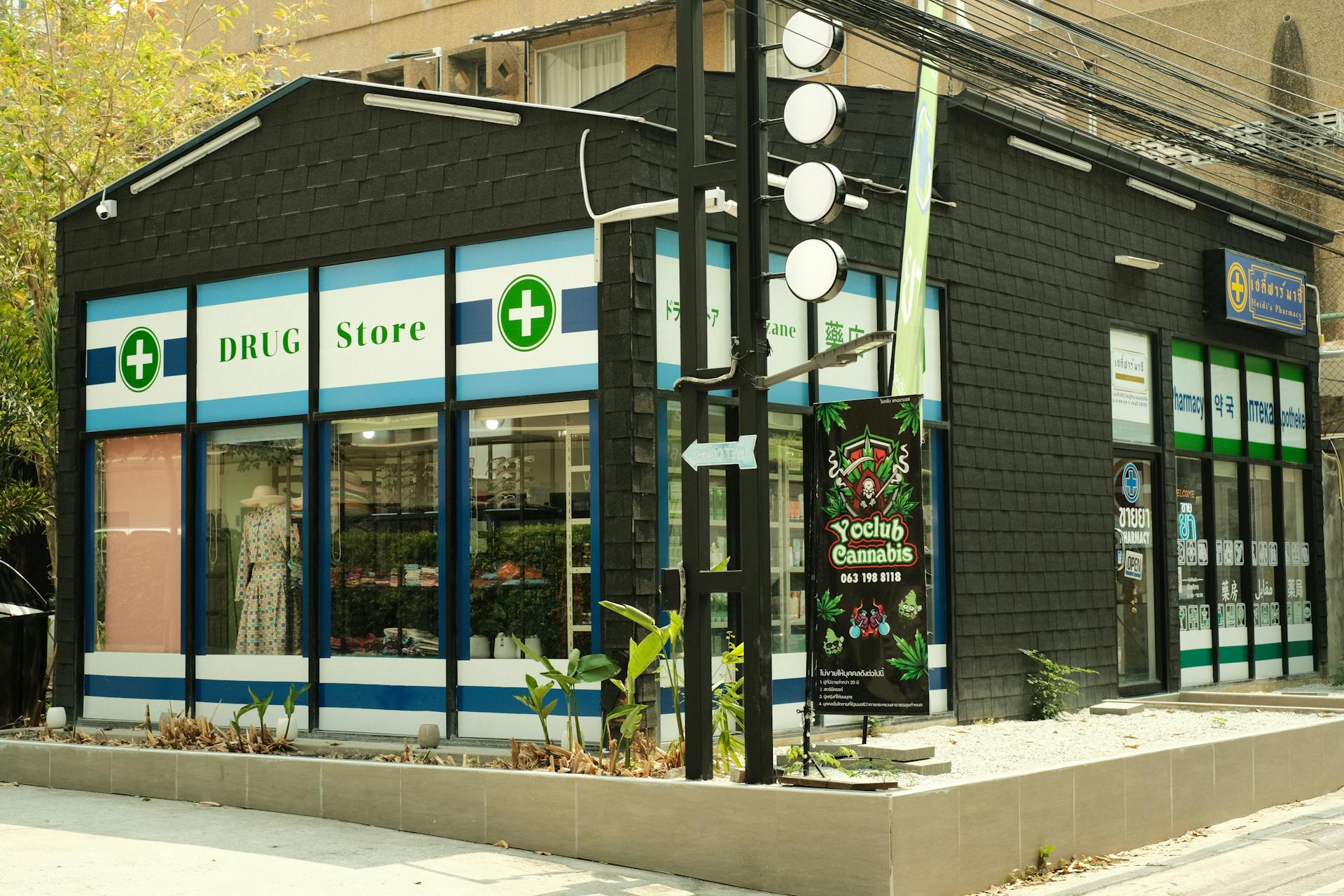 Modern urban drug store with cannabis signage and green exterior plant decor.