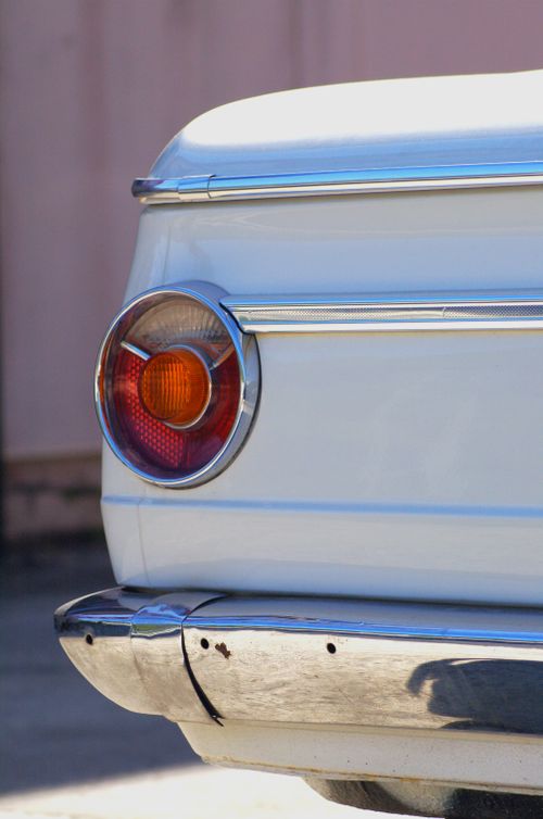 Free Detail of a classic vintage car's tail light and rear bumper with a retro design. Stock Photo
