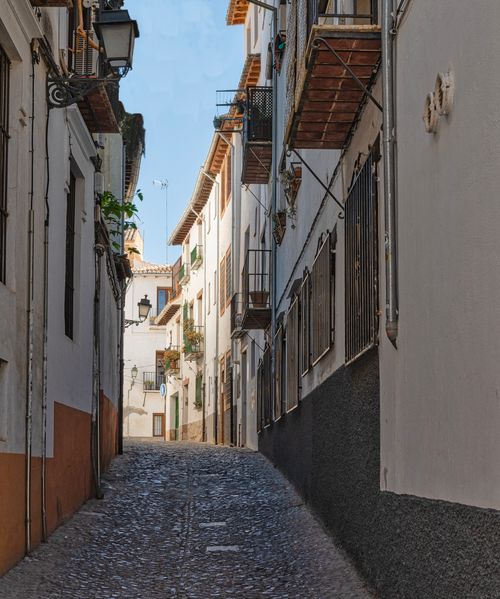 Free Idyllic narrow street with cobblestone path and traditional architecture, perfect for urban exploration. Stock Photo
