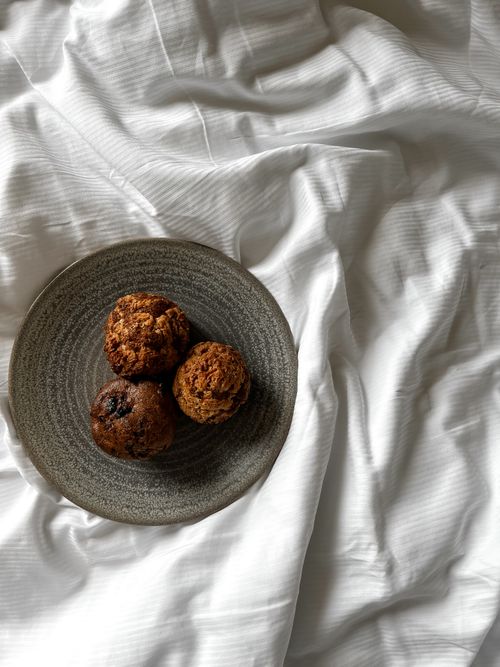 Free Tasty homemade muffins displayed on a textured plate against a white background. Stock Photo