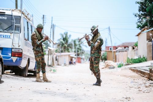 Free Two soldiers in uniform playing trumpets on a sunny city street. Stock Photo