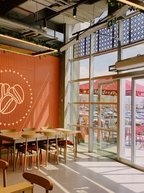 Free Cozy café interior with window views and stylish seating in natural light. Stock Photo