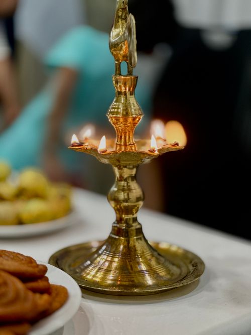 Free Close-up of a decorative brass lamp with glowing flames, set on a table. Stock Photo