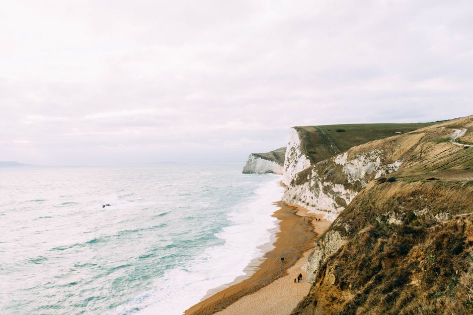 Breathtaking aerial view of the Durdle Door coastline, featuring stunning cliffs and serene waters.