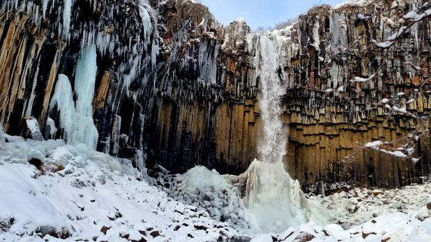 A waterfall is covered in ice and snow