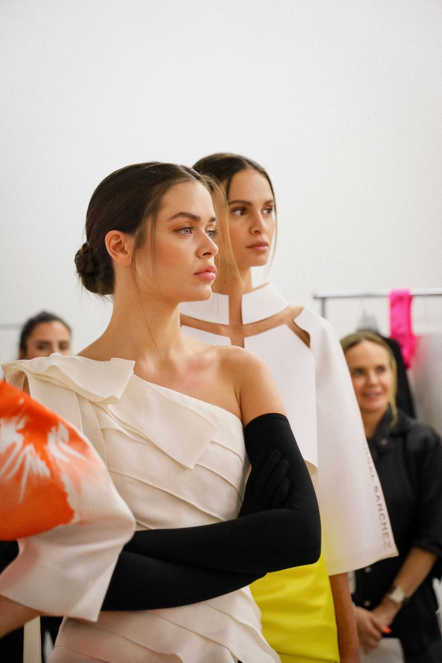 Backstage models waiting in soft light before a fashion week show