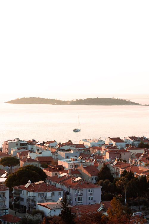 Free Scenic aerial view of a coastal town in İzmir, Türkiye during sunset, highlighting urban and sea landscapes. Stock Photo