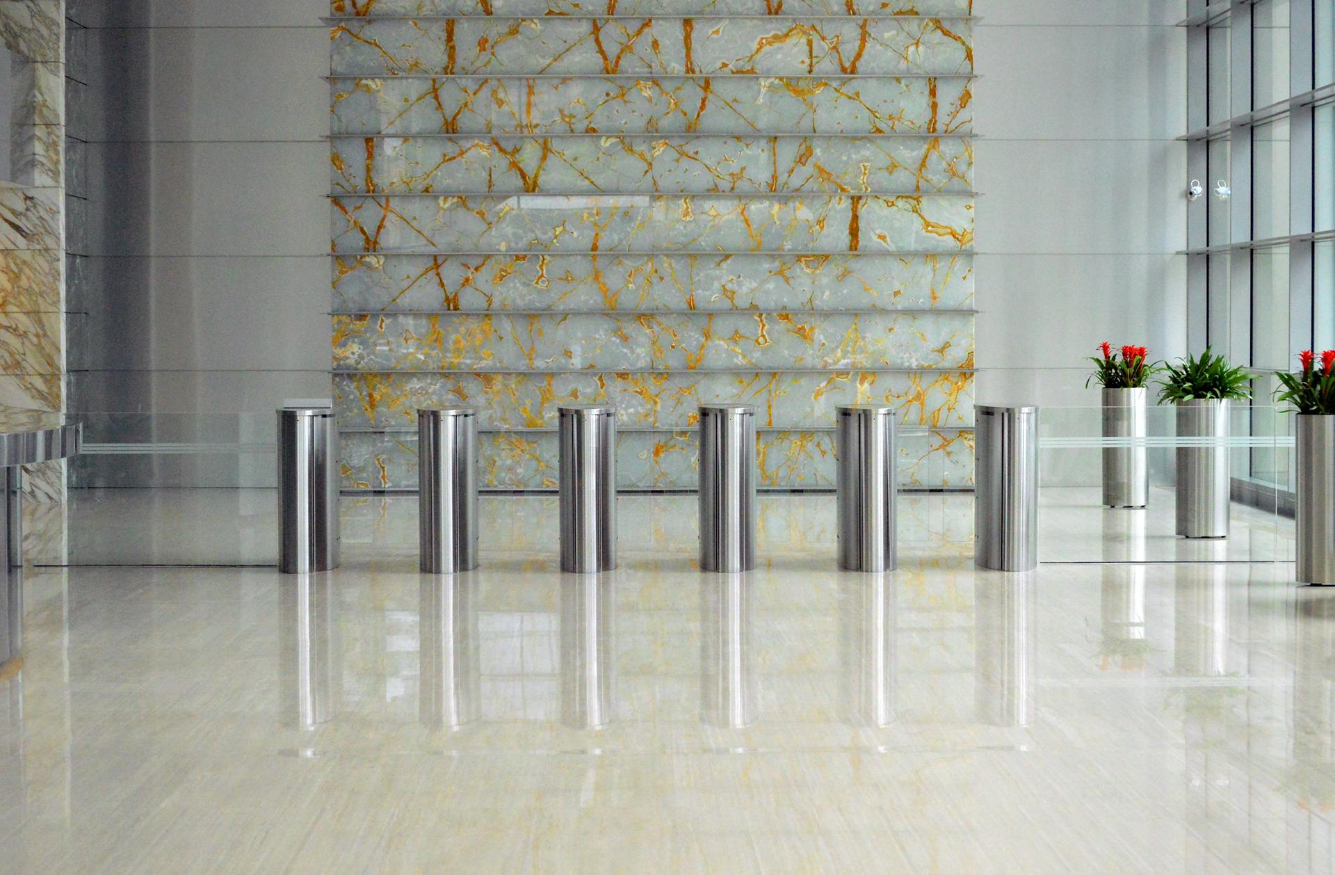 A sleek corporate lobby featuring marble walls, metal dividers, and glass windows for a sophisticated design.