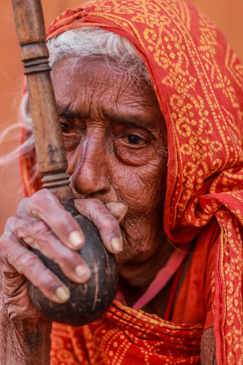 Woman In Orange Veil Holding Brown Pipe