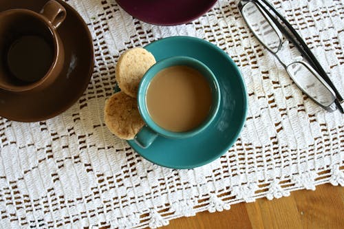 Free Green Ceramic Cup With Coffee Beside 2 Round Pastry Stock Photo