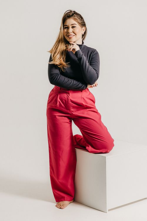 Free Stylish woman posing in bright outfit against a minimalist studio background. Stock Photo