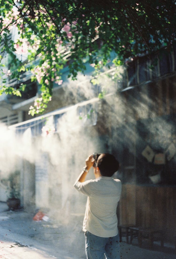 Back View Of A Photographing Man On The Street