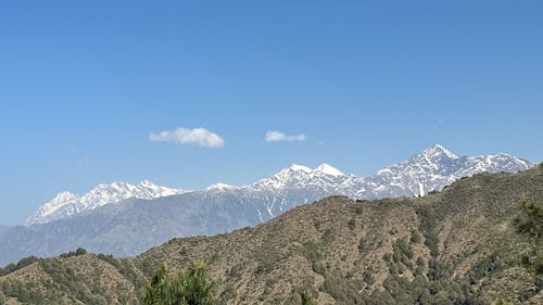 Bir Biling Dhauladhar mountain range sky blue brown white snow clouds landscape