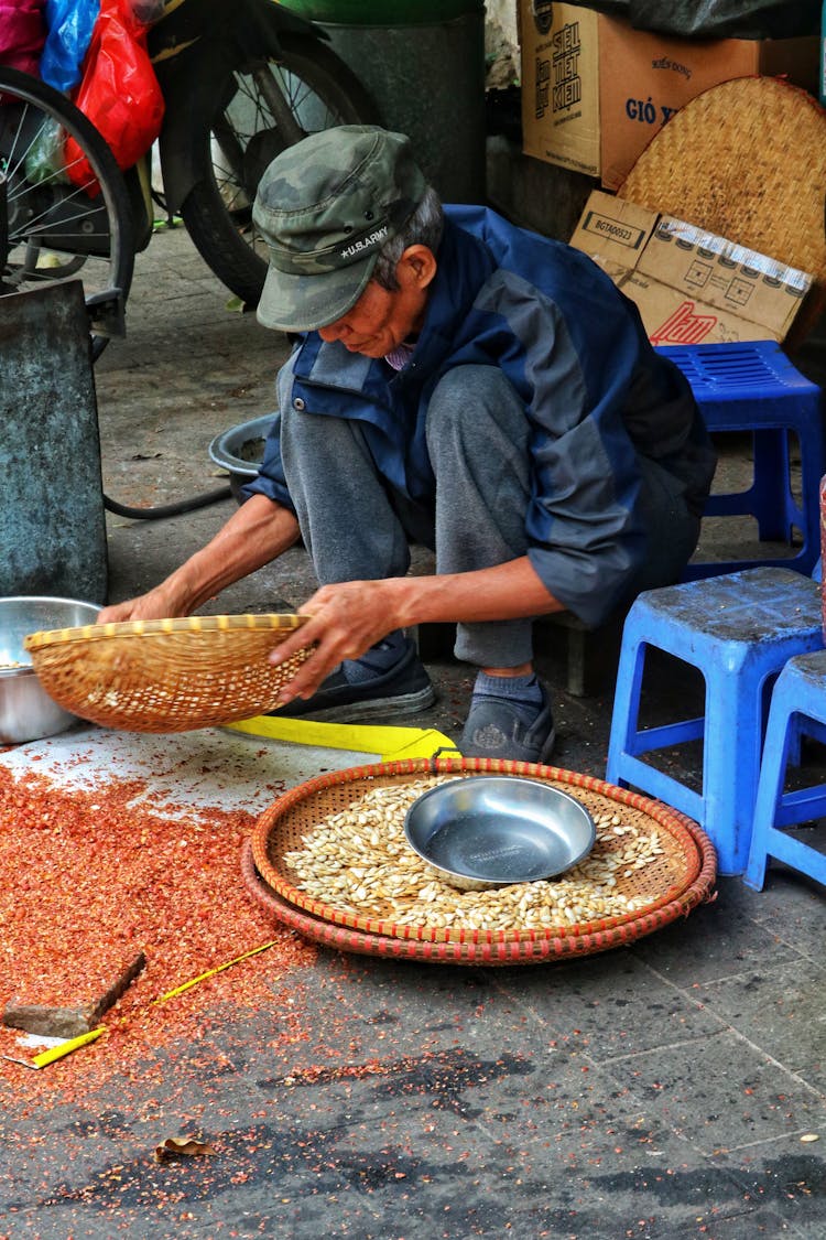 Man Sifting The Grain