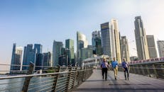 城市专业人士走在人行天桥上，背景是新加坡的天际线