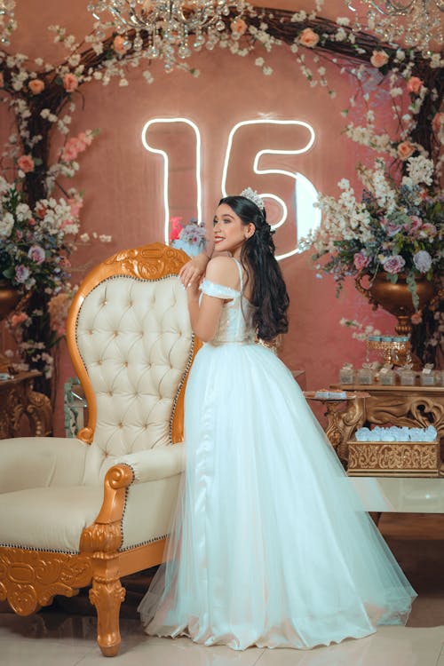 Free A Teenage Girl in a White Dress Posing at her Birthday Party Stock Photo