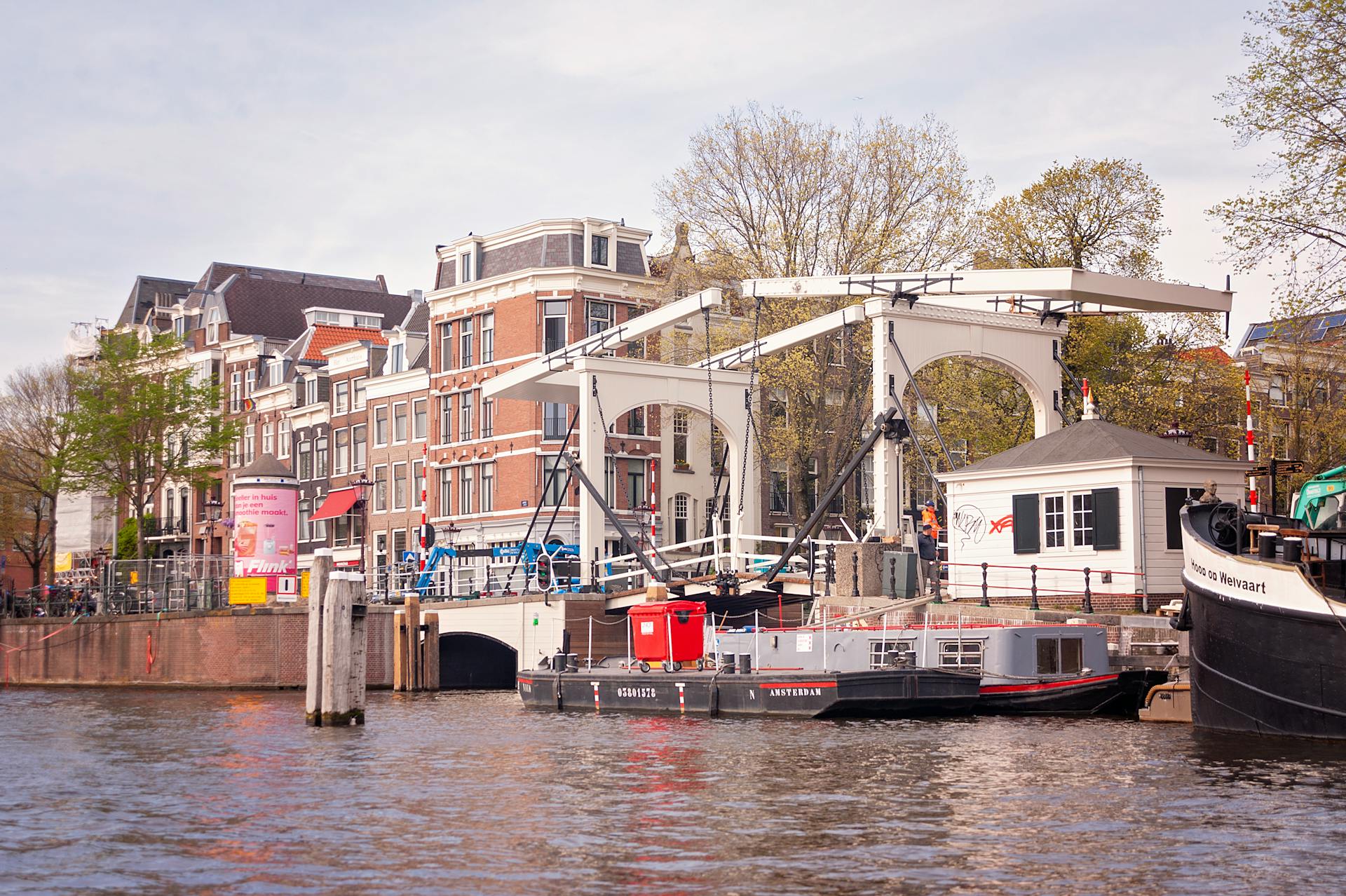 Charming view of the Walter Süskindbrug over Amsterdam's Nieuwe Herengracht with canal boats.