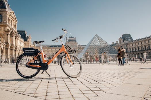 Eco-friendly rental bike parked near the Louvre Pyramid on a sunny day in Paris, France.