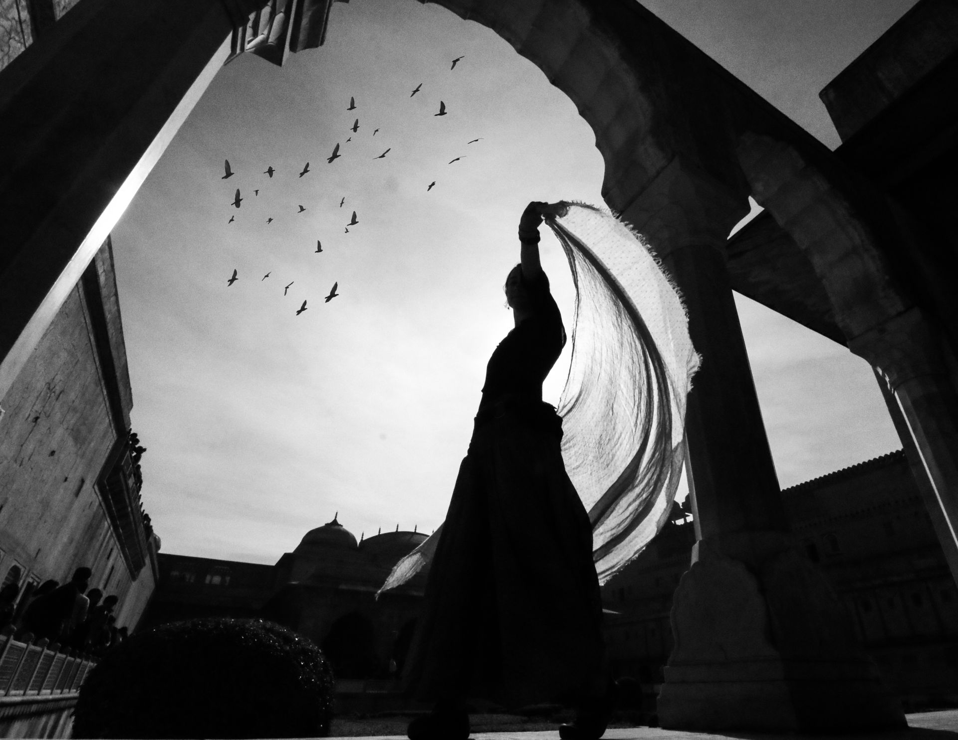 Silhouette of a dancer moving with sheer flowing fabric