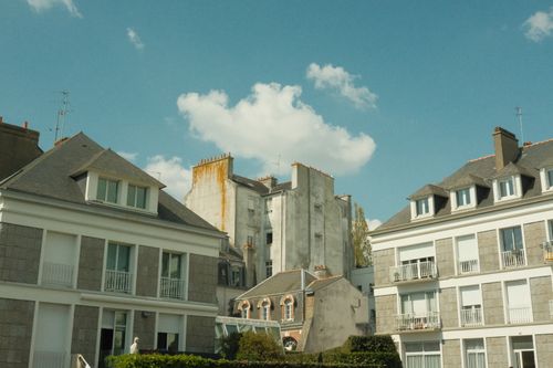 Free Scenic view of traditional urban buildings with clear blue sky and fluffy clouds. Stock Photo