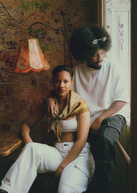 African couple relaxing indoors in a stylish Budapest cafe, exuding charm and intimacy.