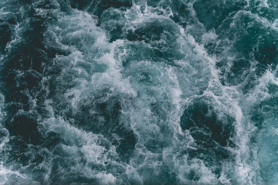 Powerful ocean waves captured from above, showcasing the dynamic movement and blue hues of the sea.