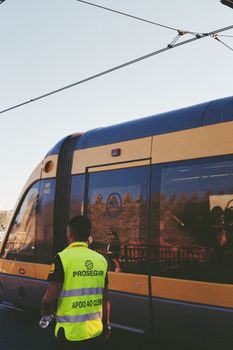 A security officer stands by a tram at a station in Porto, Portugal, captured on film.
