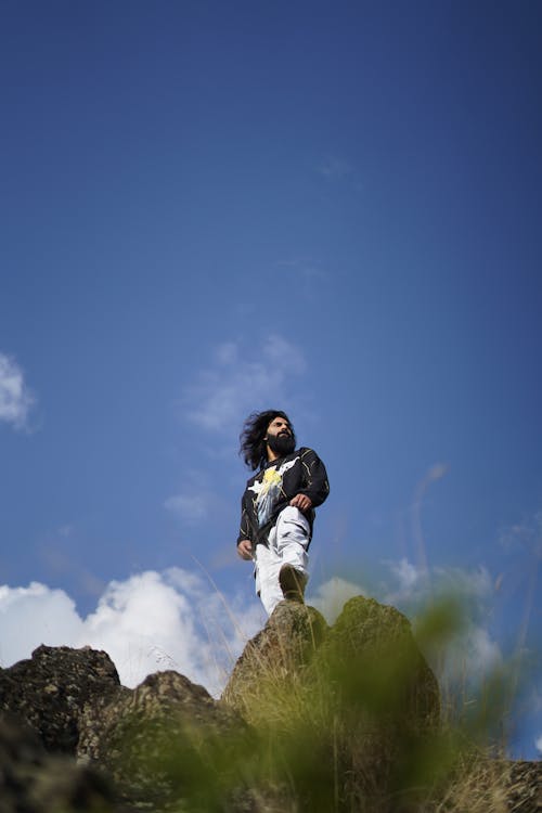 Man Posing on Rock under Clear Sky