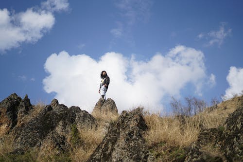 Man Standing on a Rock Formation and Looking at a View 