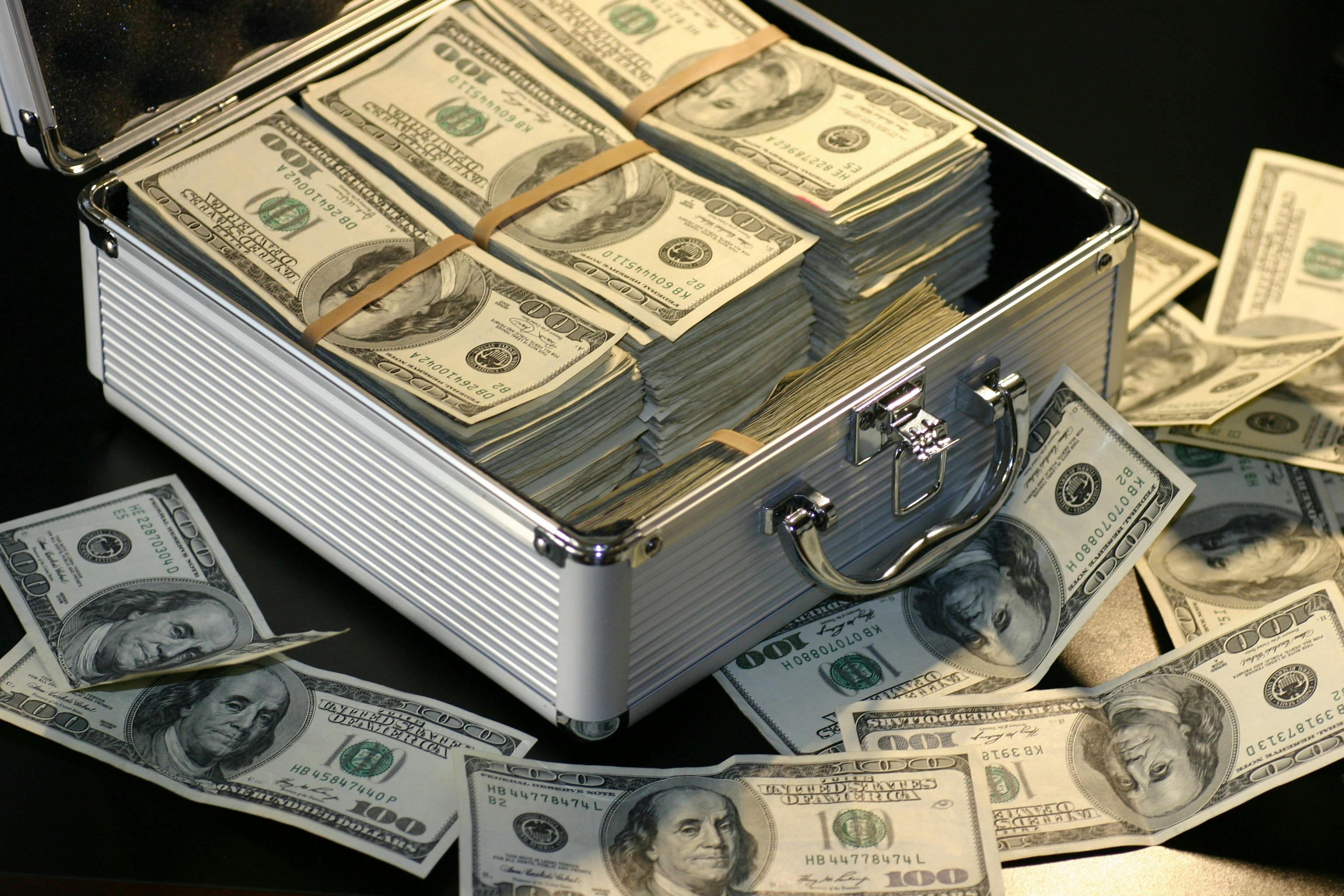 Grey metal case of hundred dollar bills. | Photo: Pexels