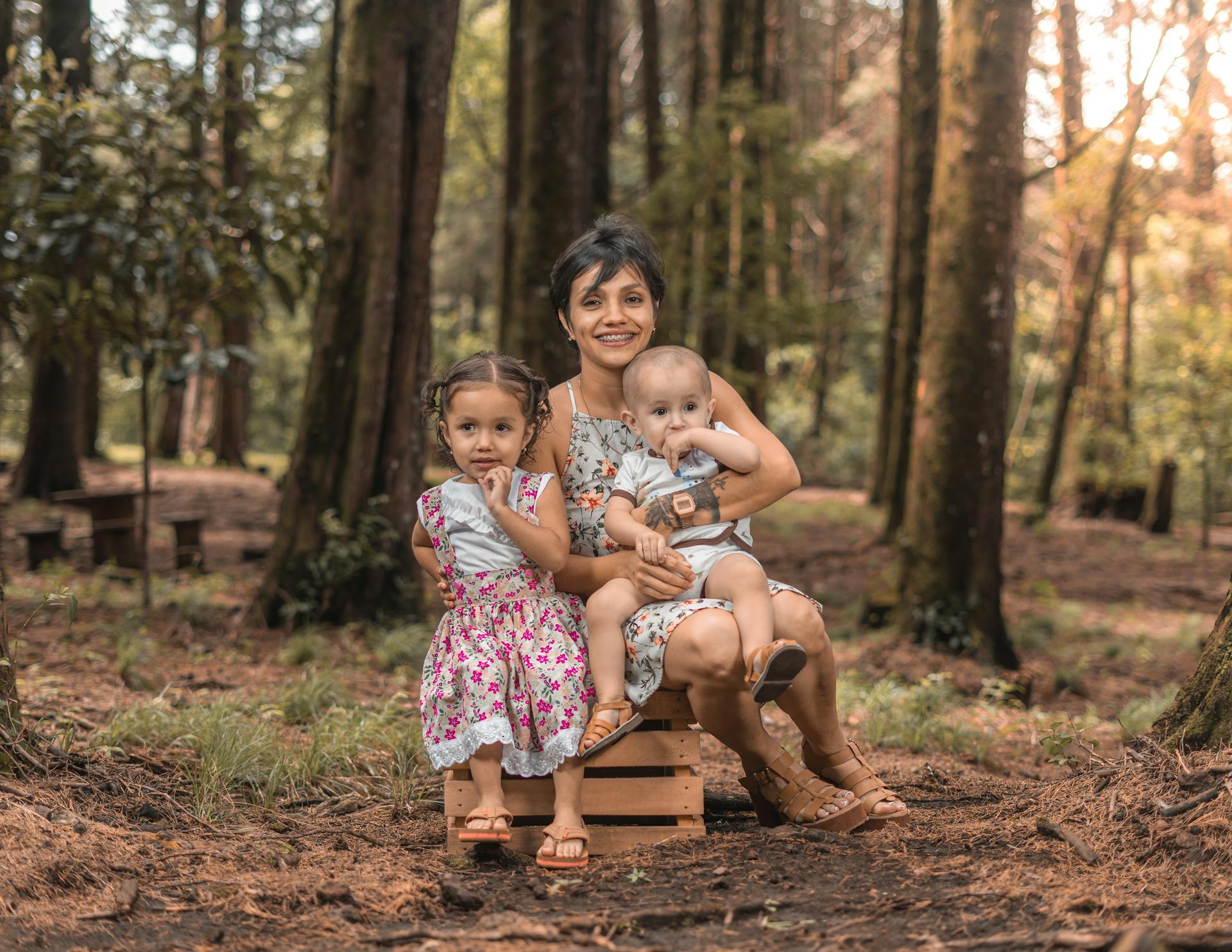 Woman Sitting on a Crate with Two Children