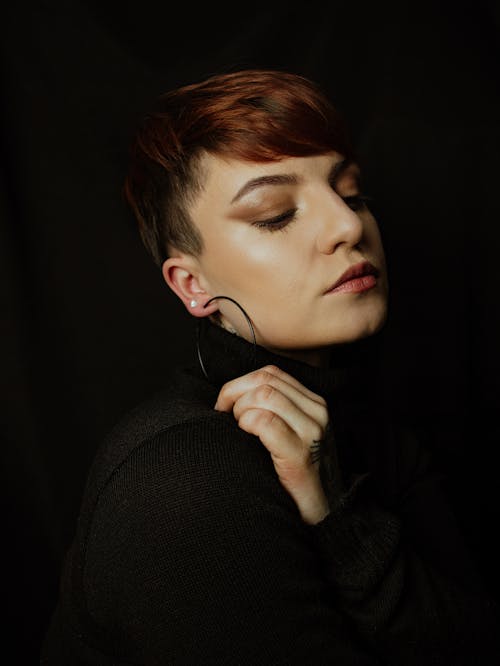 Portrait of Woman Wearing Hoop Earrings on Black Bac