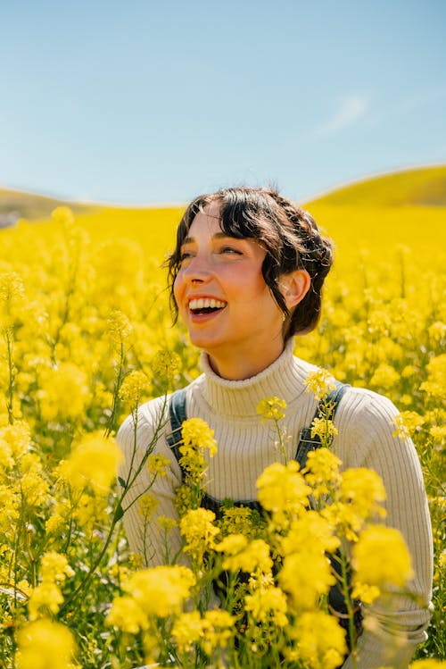 Portrait of a Smiling Woman in a Field of Yellow Flowers