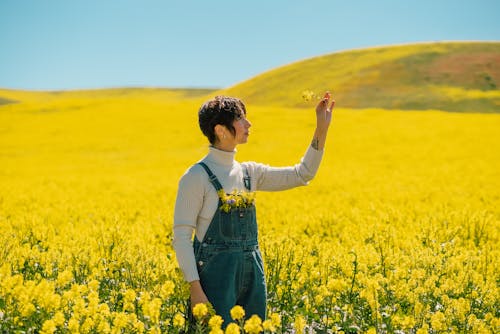 A Young Woman Standing in a Vast Field of Yellow Flowers