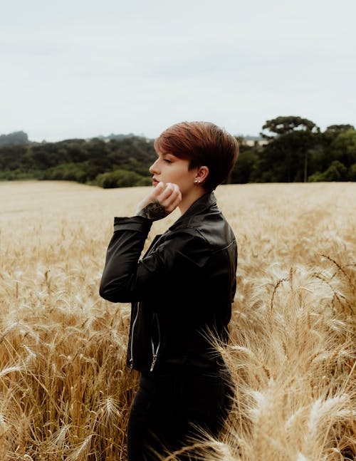 Young Brunette Wearing a Leather Jacket Standing in a Summer Field