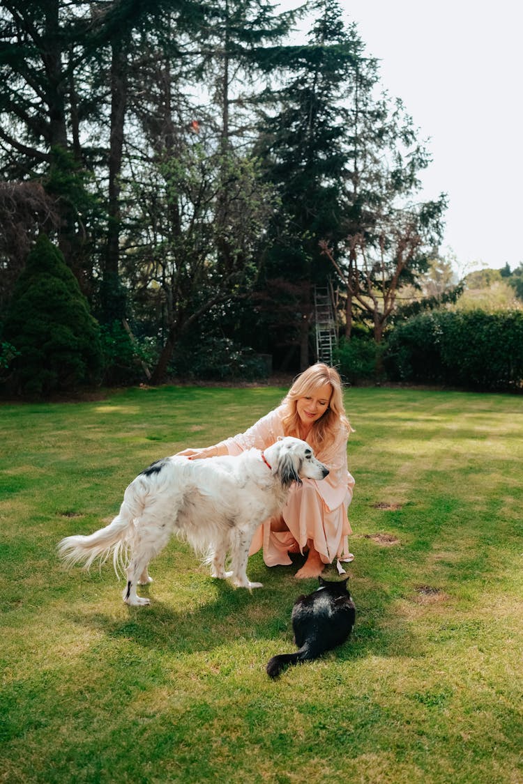 Woman With Dog And Cat On Grass