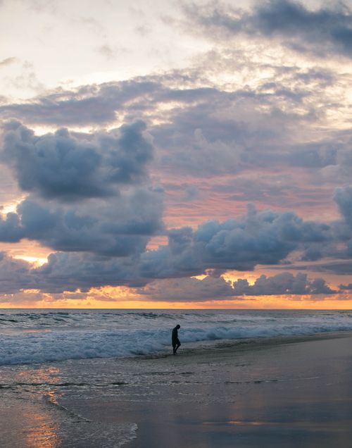 Free A captivating silhouette against a dramatic sunset sky on Acapulco beach, Mexico. Stock Photo